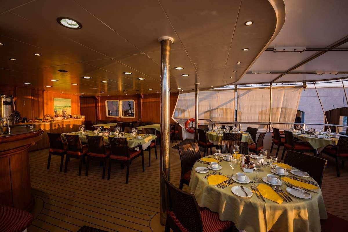 a restaurant with tables and chairs aboard PAN ORAMA II Yacht for Charter