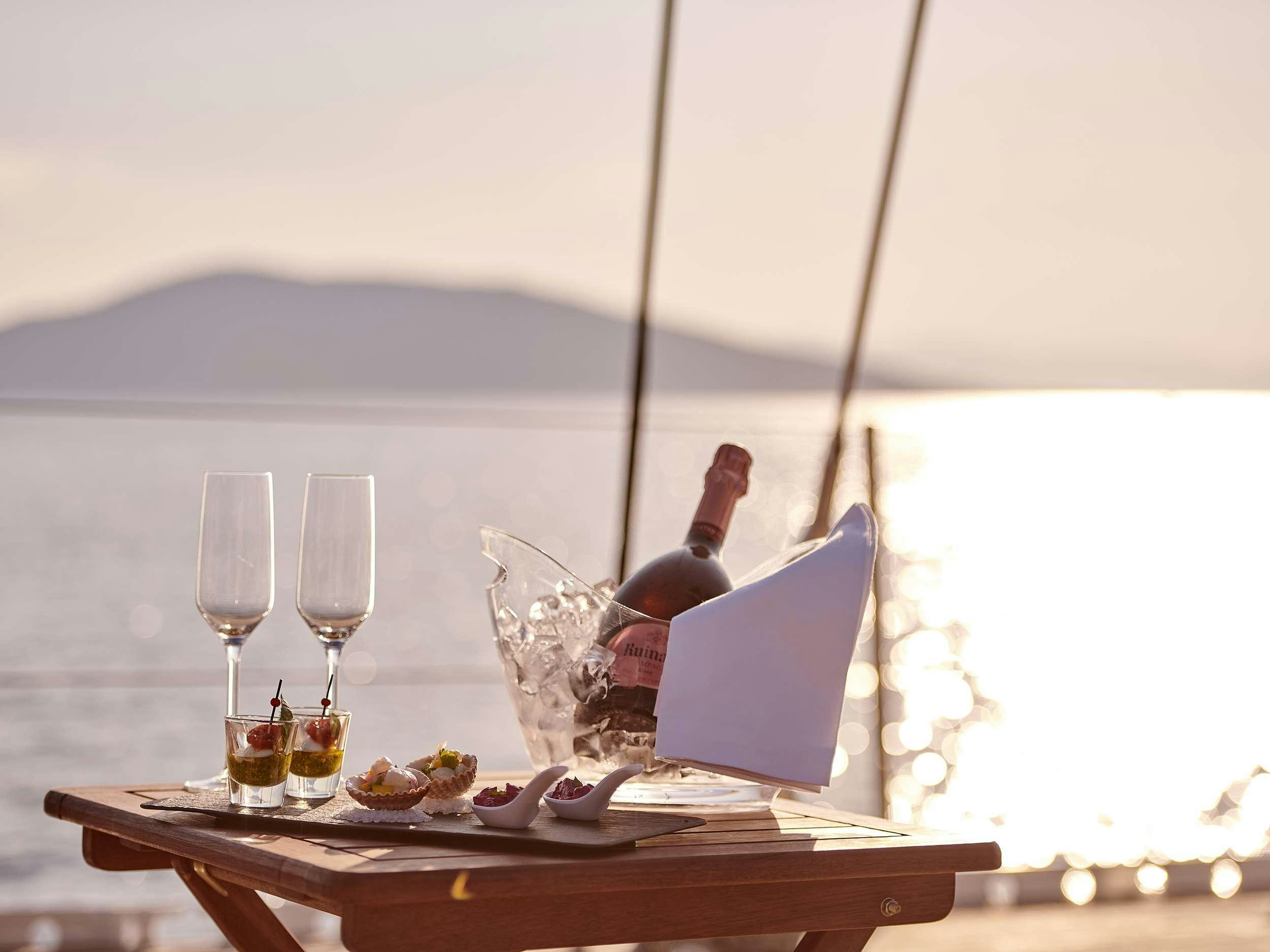 a table with food and wine aboard AIZU Yacht for Charter