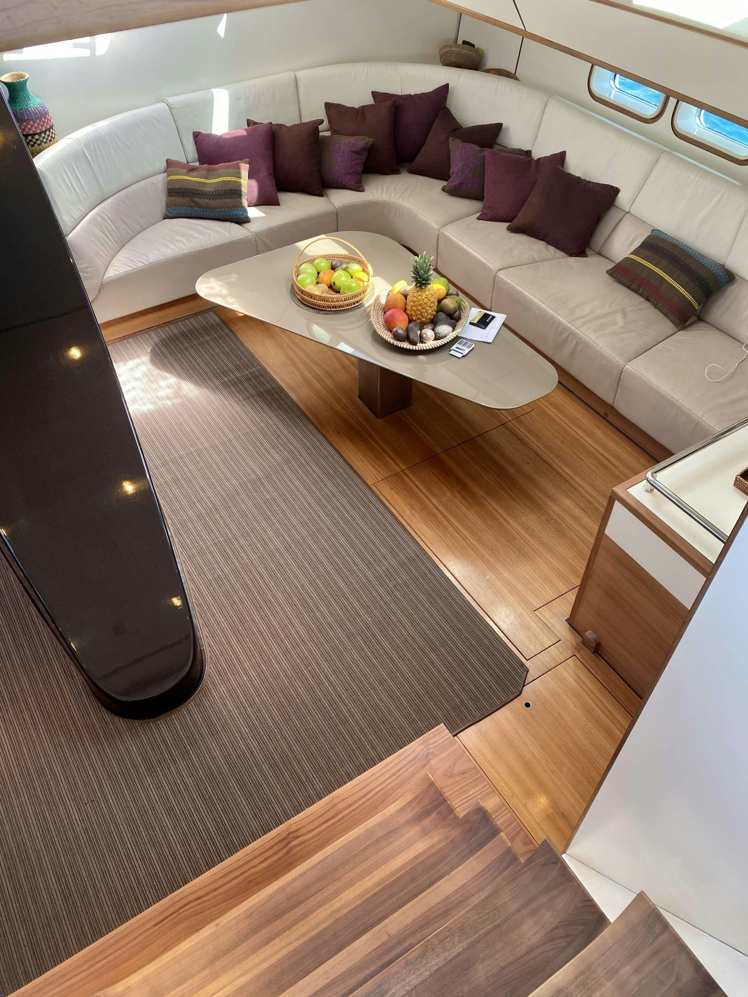 a living room with a couch and coffee table aboard AIZU Yacht for Charter