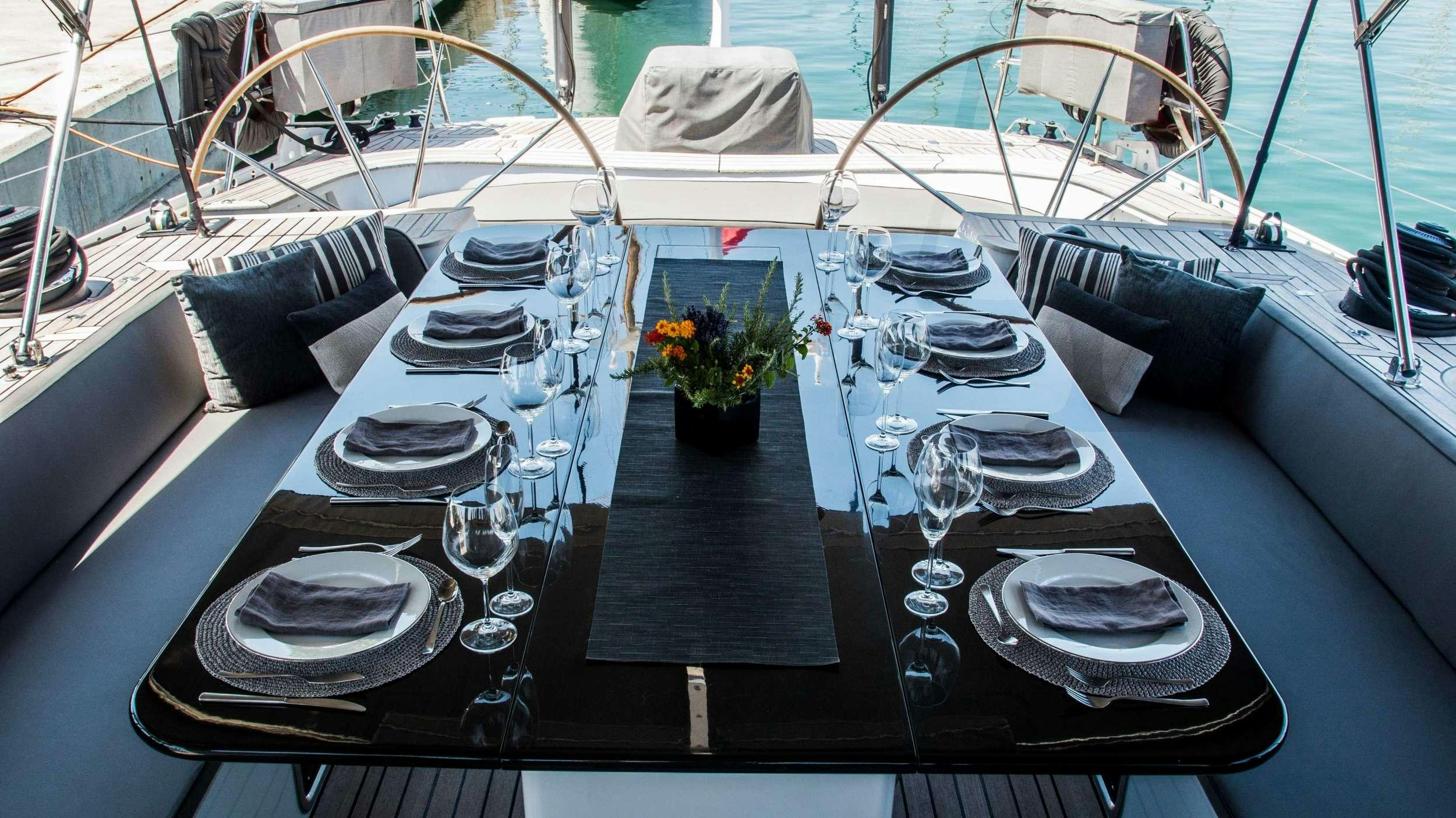 a table with plates and glasses on it aboard AIZU Yacht for Charter
