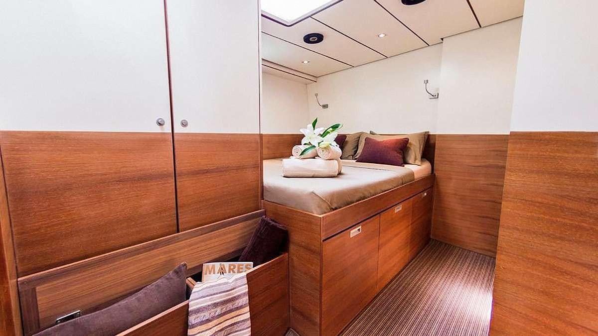 a room with a bed and a dresser aboard AIZU Yacht for Charter