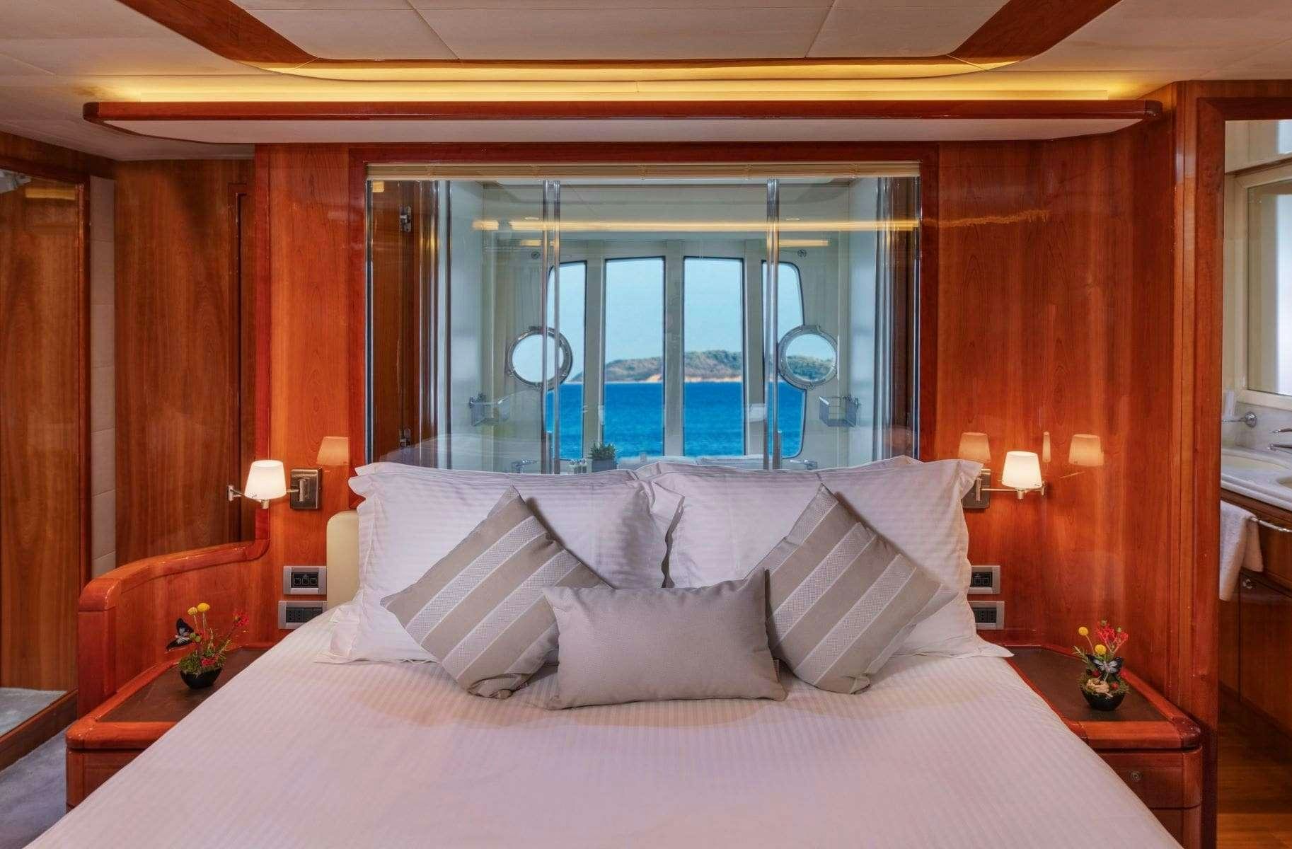 a bed with white sheets and pillows aboard ANNOUKA Yacht for Charter