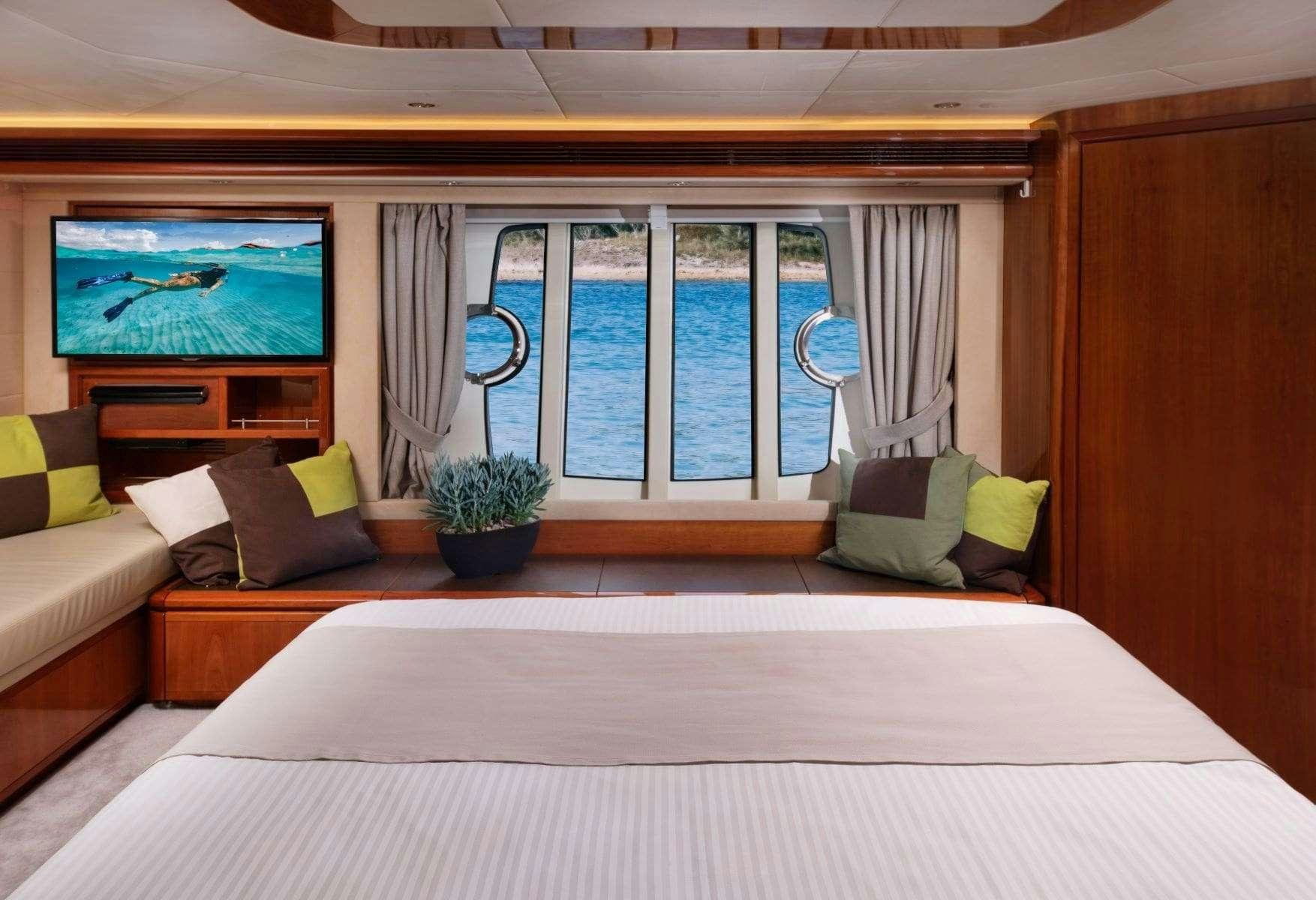 a bed with a large window aboard ANNOUKA Yacht for Charter