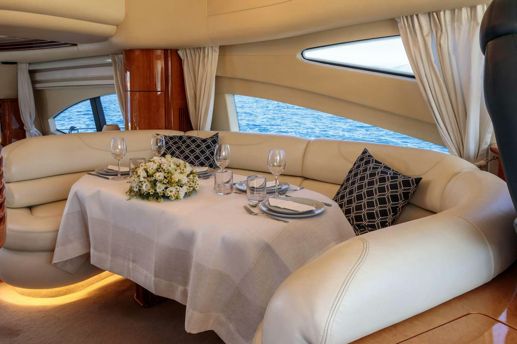 a white table with a white tablecloth and a white couch with flowers on it aboard DREAM Yacht for Charter