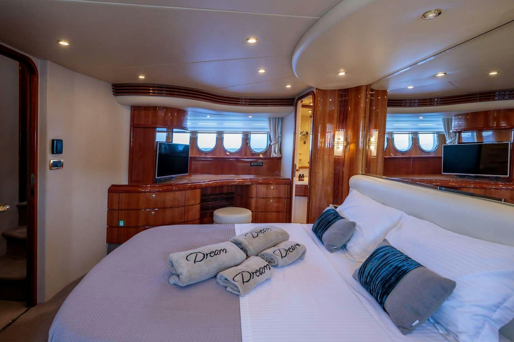a room with a bed and a television aboard DREAM Yacht for Charter