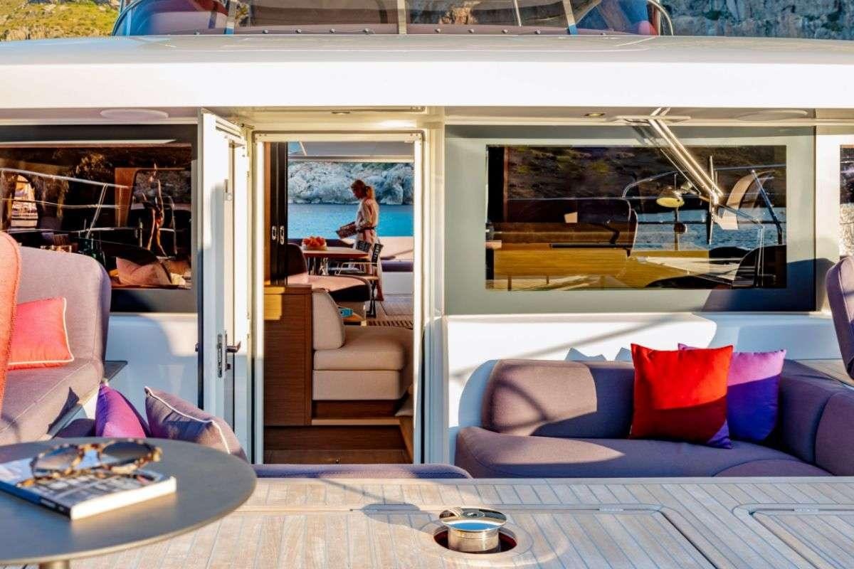 a room with a couch and a table and a window aboard VALIUM 67 Yacht for Charter