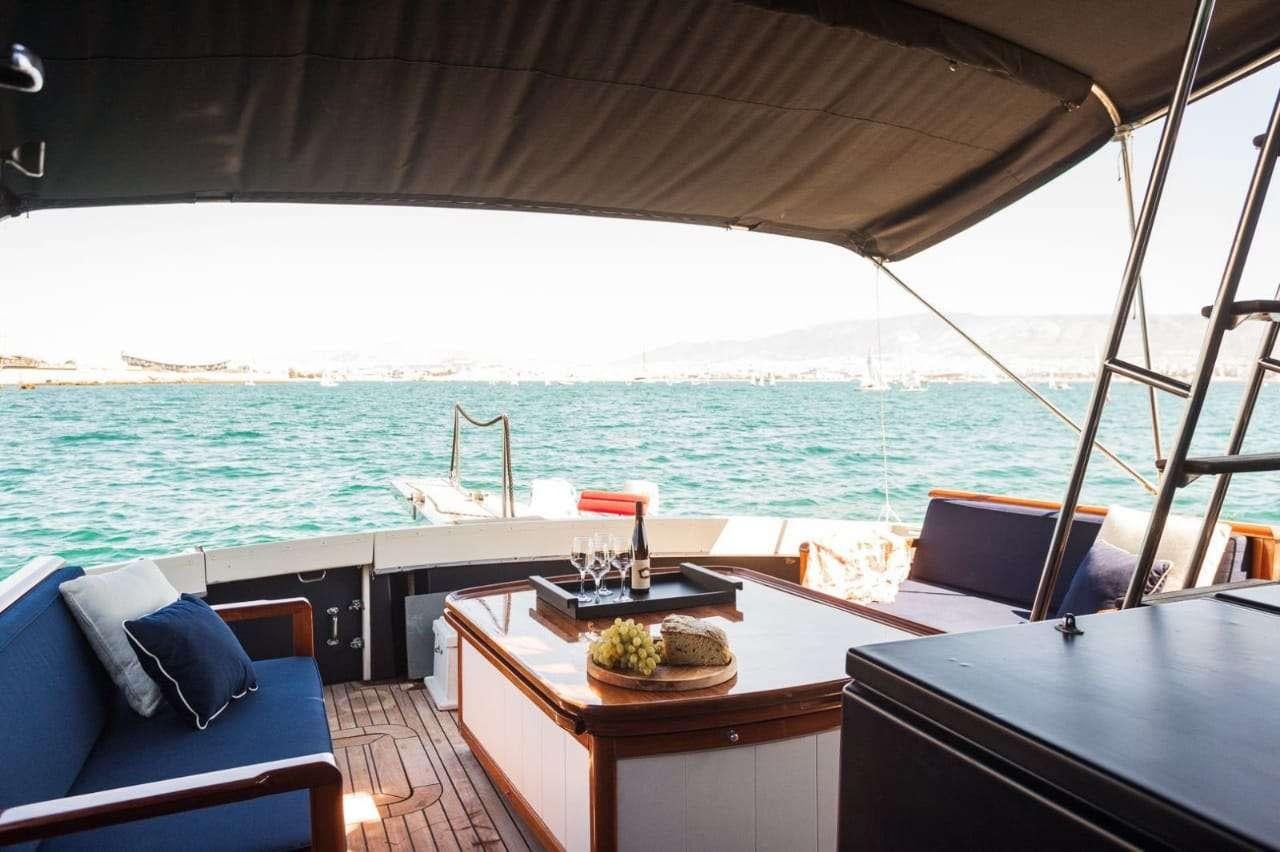 a boat with a table and chairs on the deck aboard Theoxenia Yacht for Charter