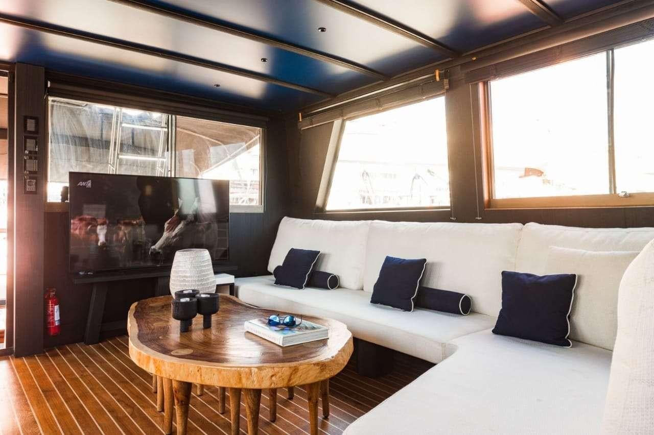 a room with a table and couches aboard Theoxenia Yacht for Charter