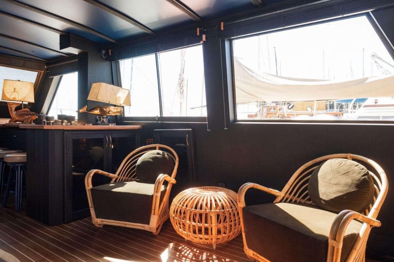 a room with a table chairs and a window aboard Theoxenia Yacht for Charter