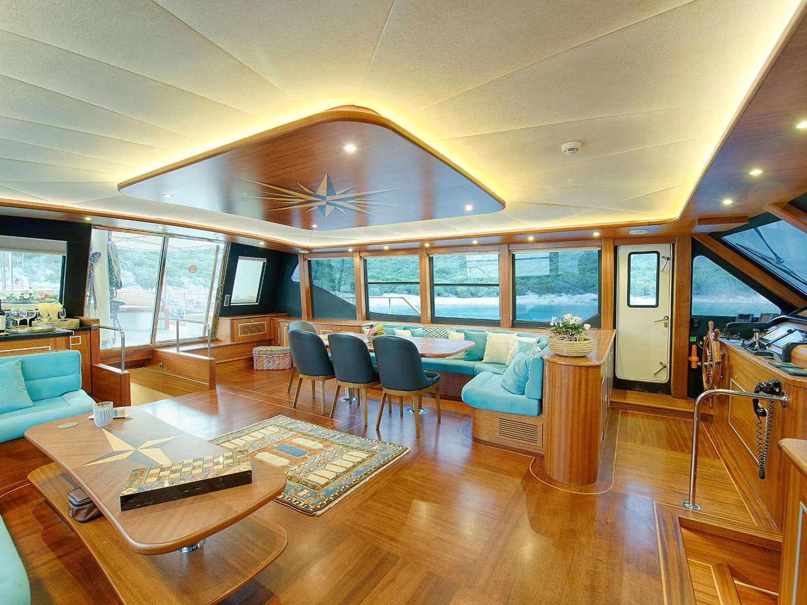a large living room with a large window aboard RIVA Yacht for Charter