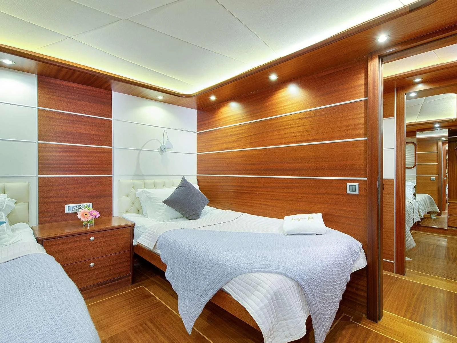a bedroom with a bed and a mirror aboard RIVA Yacht for Charter