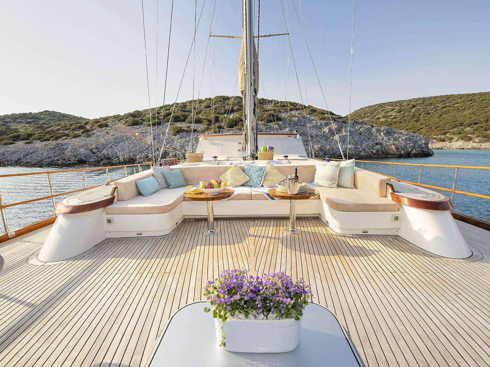 a large white lounge chair on a balcony overlooking a large body of water aboard RIVA Yacht for Charter