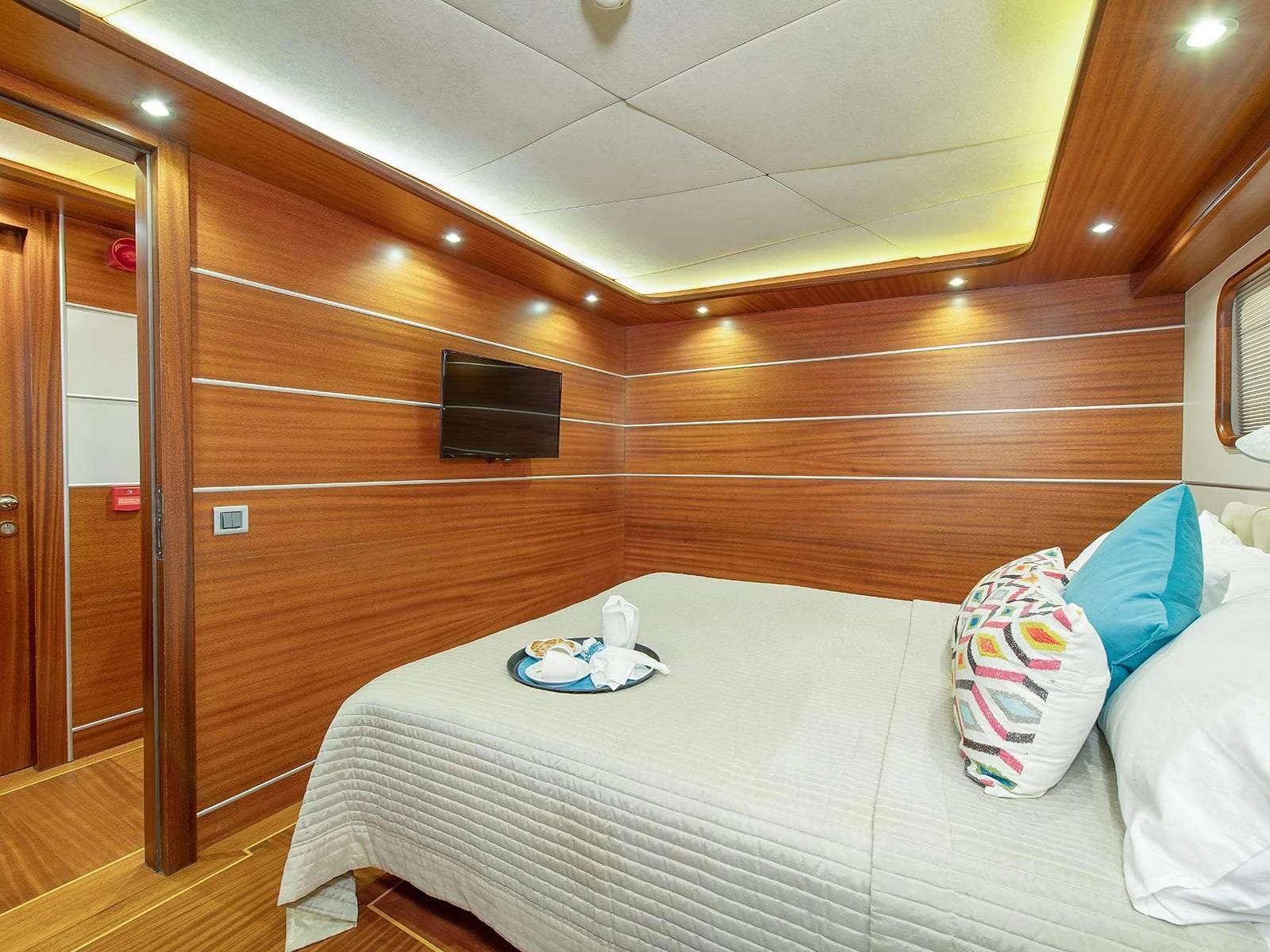 a bed with a white sheet and pillows on it aboard RIVA Yacht for Charter