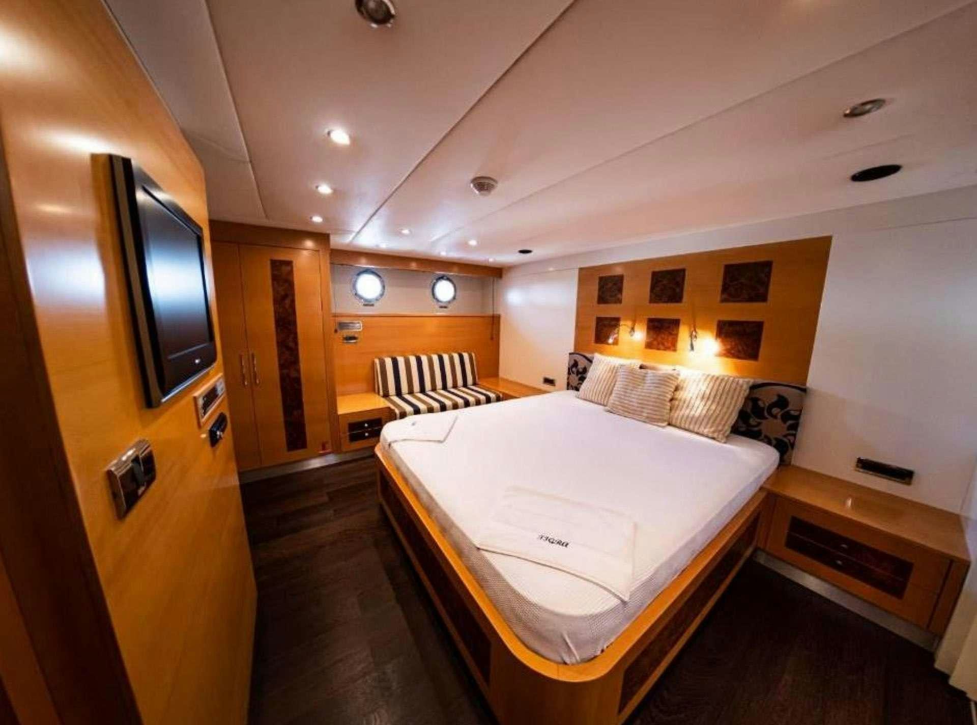 a room with a bed and a tv on the wall aboard TIGRA Yacht for Charter