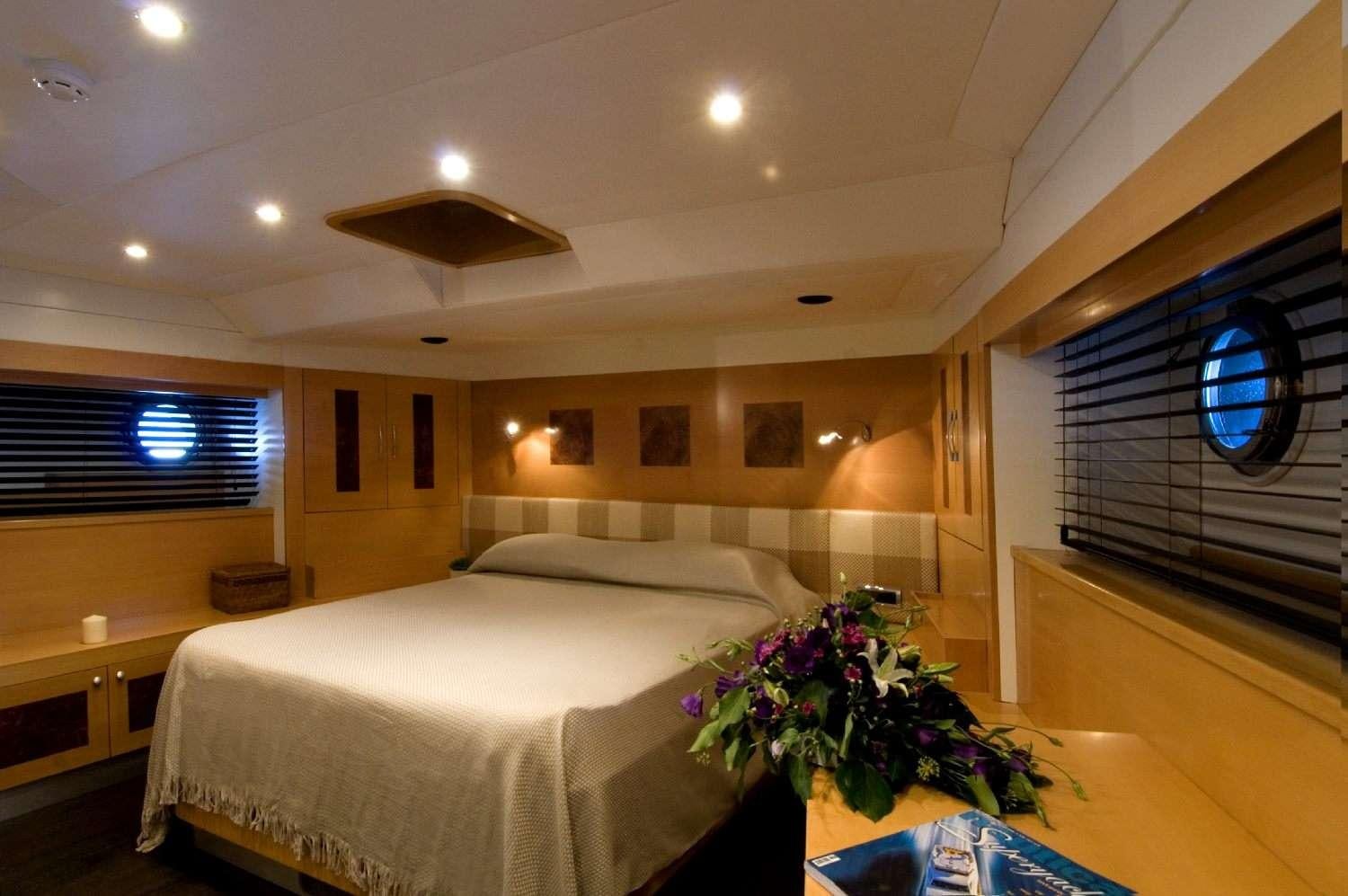 a room with a bed and a plant aboard TIGRA Yacht for Charter