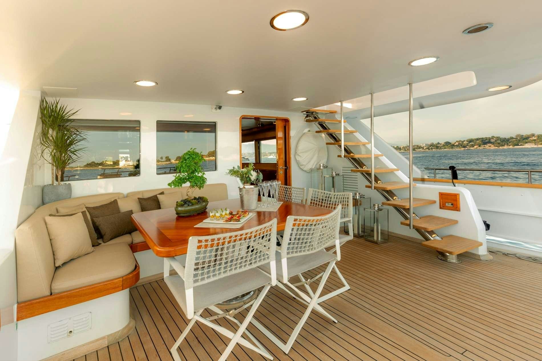 a room with a table chairs and a bench aboard ESPINOLA Yacht for Charter