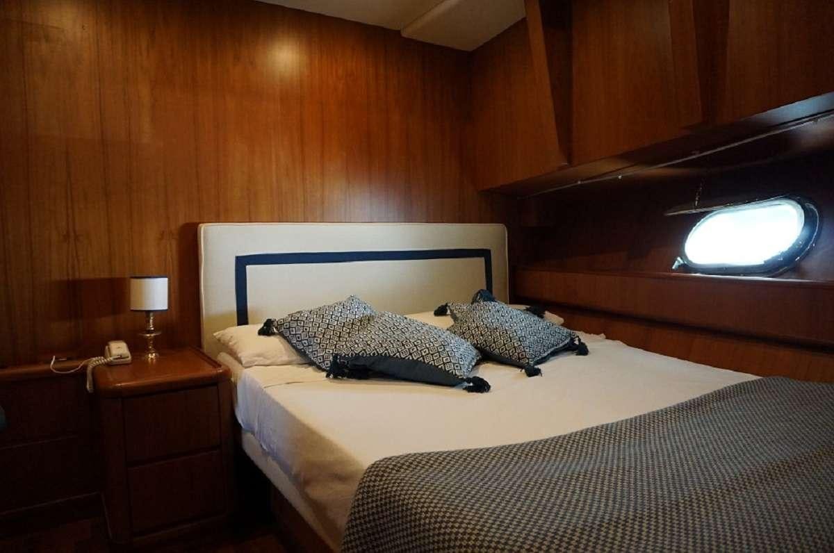 a bed with a white bed spread aboard BALU 3 Yacht for Charter