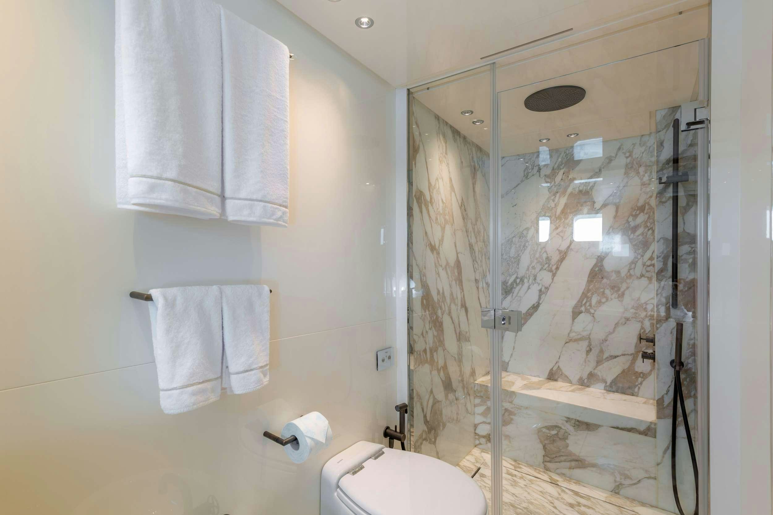 a bathroom with a glass shower aboard K1 Yacht for Charter
