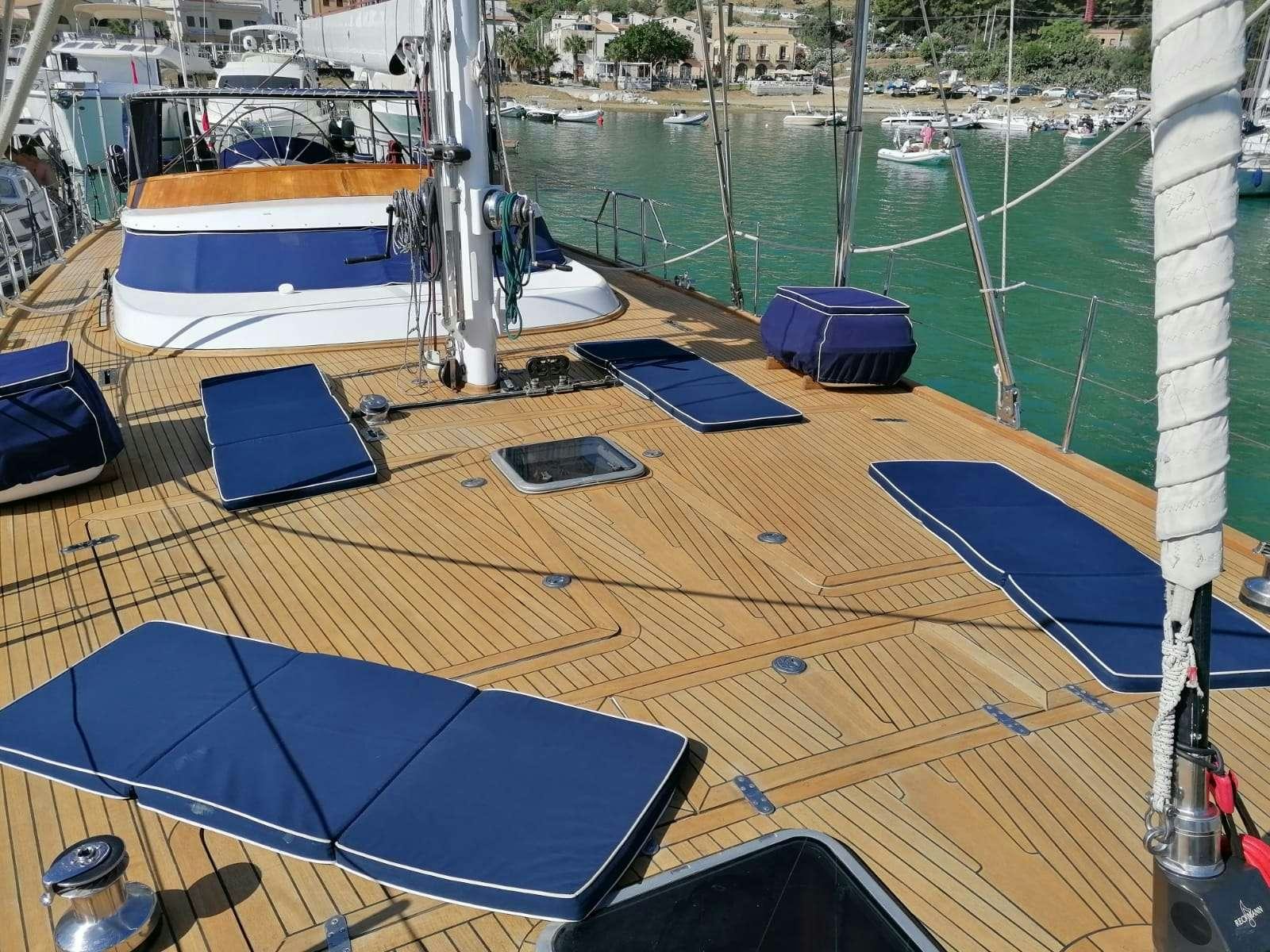 a deck with a boat and a deck with a blue tarp on it aboard MALIZIA Yacht for Charter