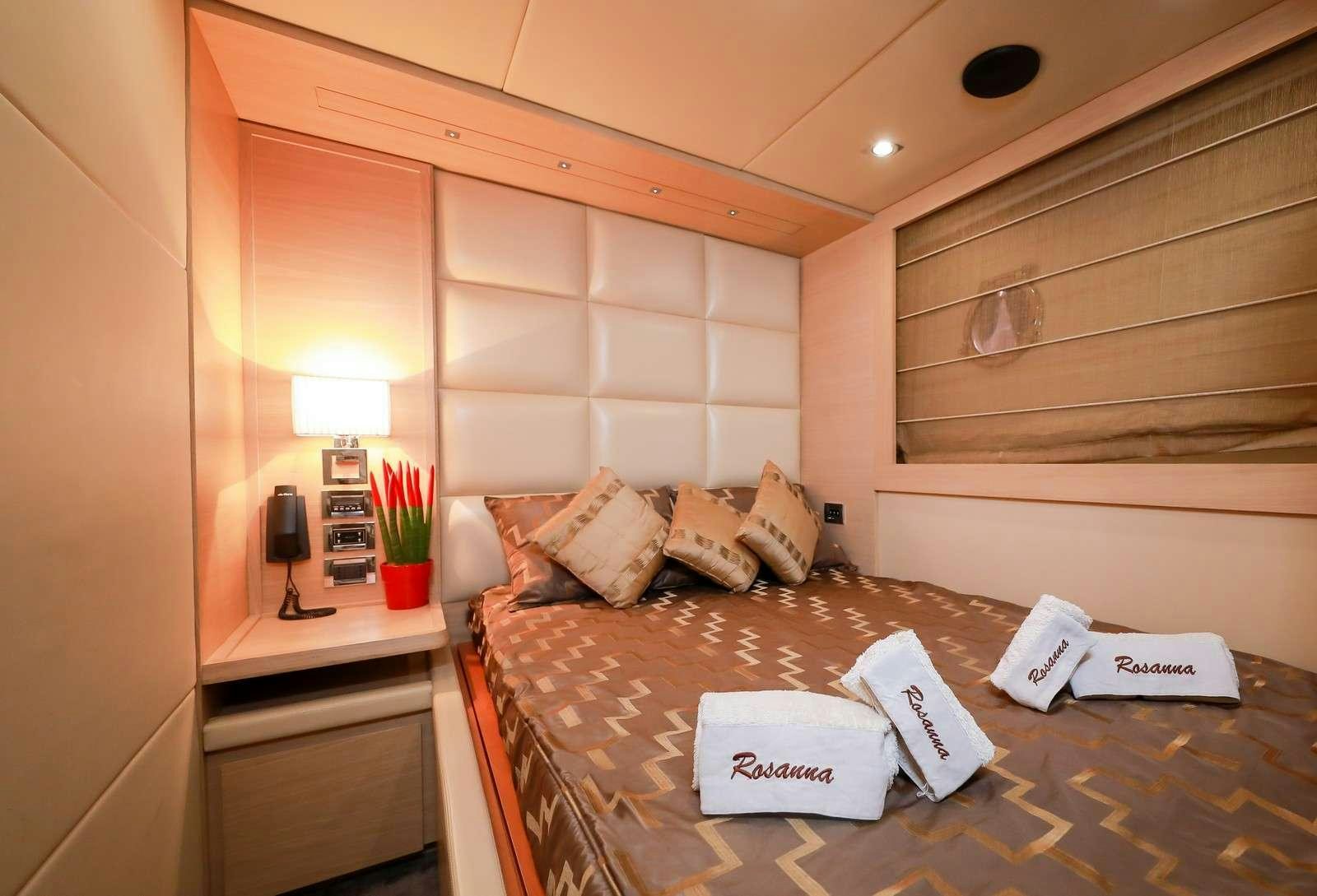 a bed with a white sheet and a brown and white bed spread aboard FOR EVER ROSANNA Yacht for Charter