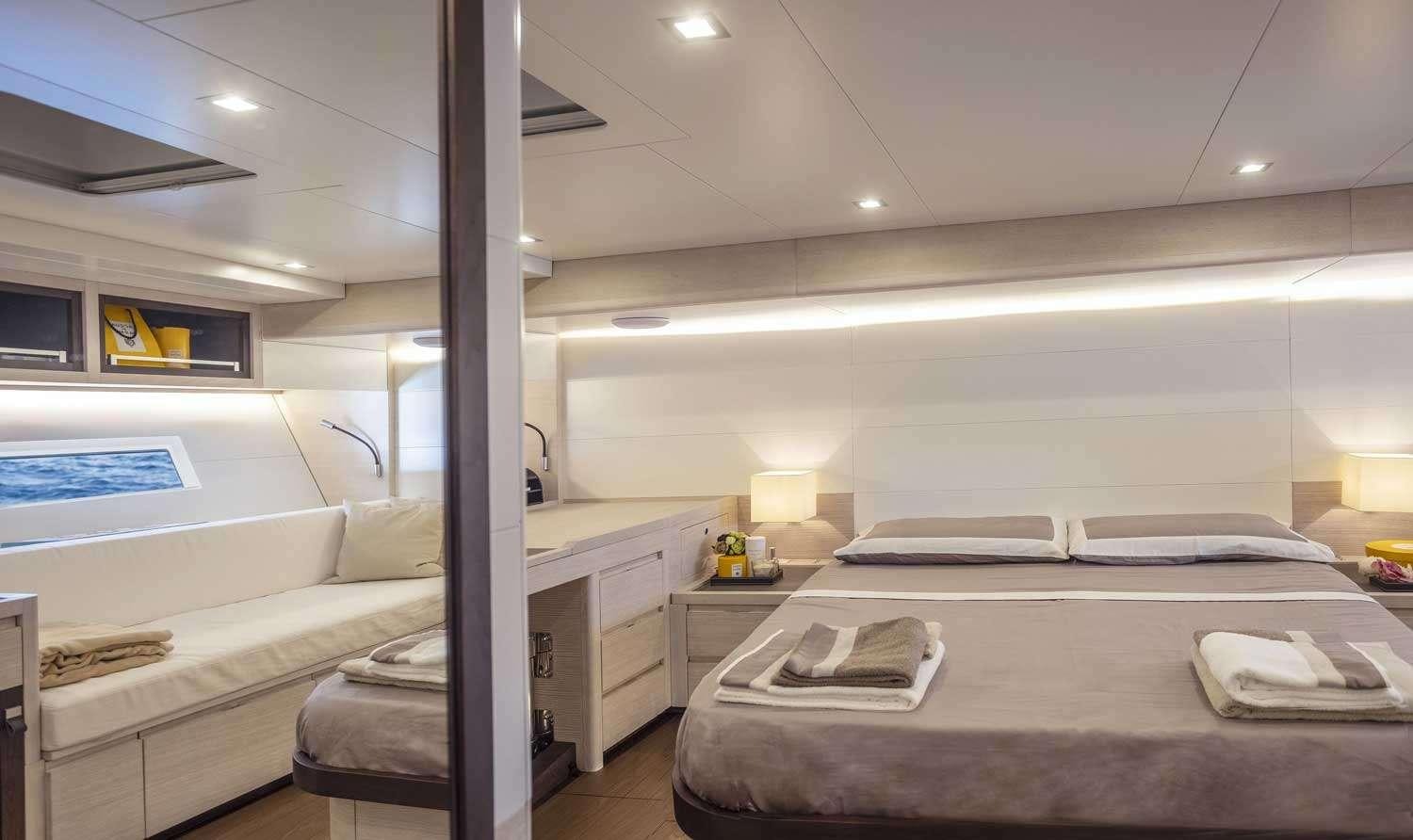 a room with a bed and a desk aboard MINDFULNESS Yacht for Charter