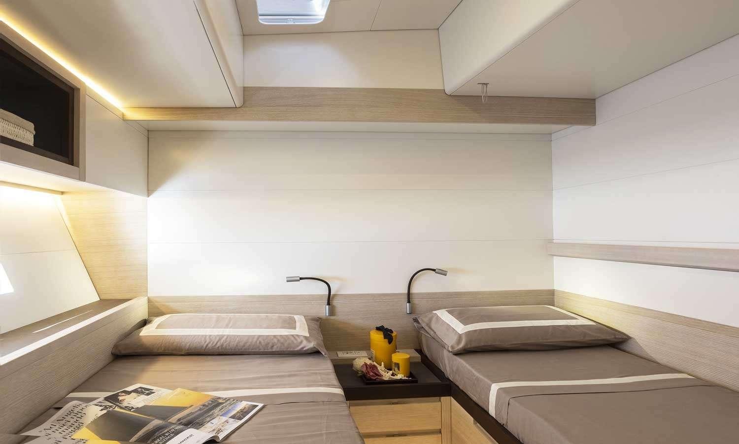 a room with a bed and a desk aboard MINDFULNESS Yacht for Charter