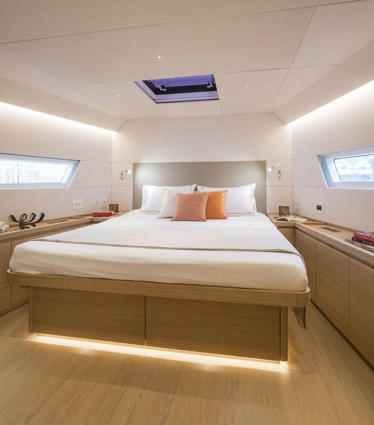 a bed with a white cover aboard KARMA Yacht for Charter