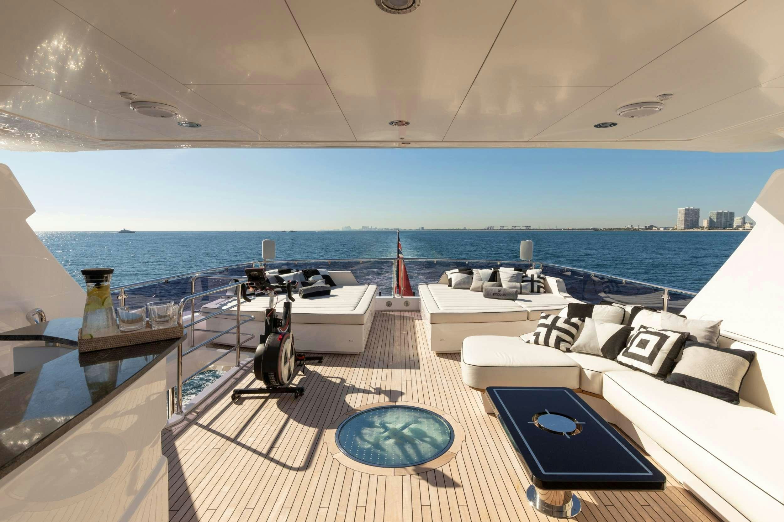 a lounge area with a pool and a large body of water in the background aboard EXODUS Yacht for Charter