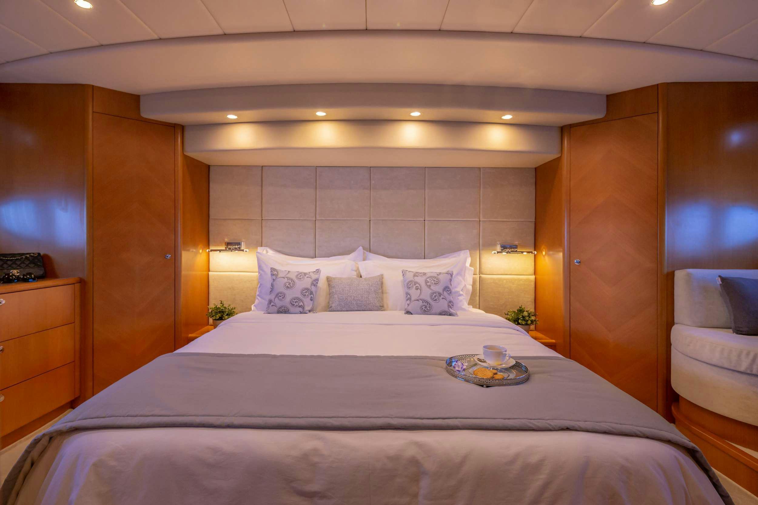 a bed with a white sheet and pillows aboard LEGEND Yacht for Charter