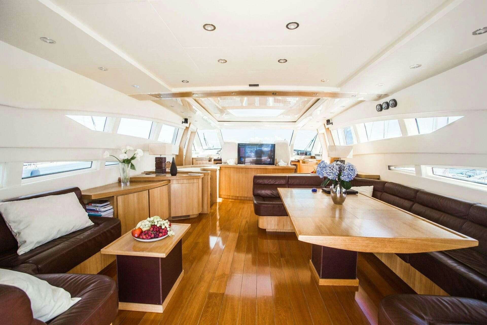 a room with a wood floor and a wood table with a plant on it aboard DOUBLE D Yacht for Charter