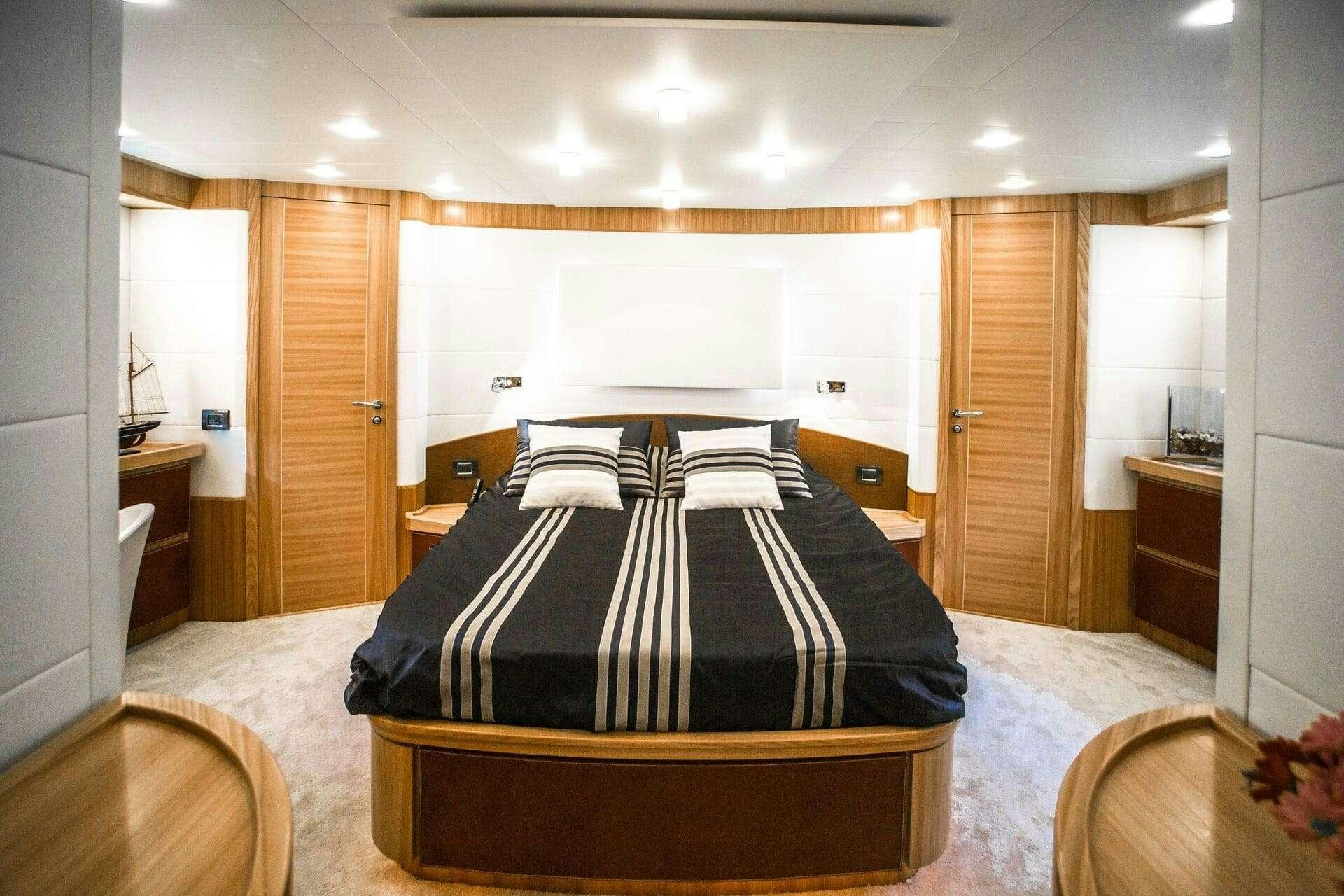 a bedroom with a bed and a dresser aboard DOUBLE D Yacht for Charter