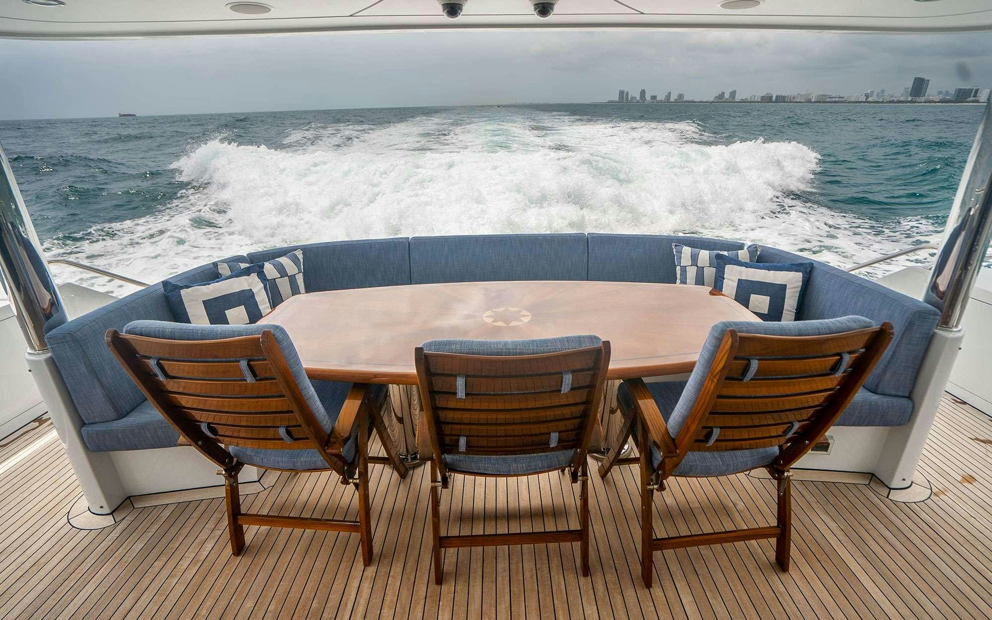 a table and chairs on a deck aboard RISK & REWARD Yacht for Charter