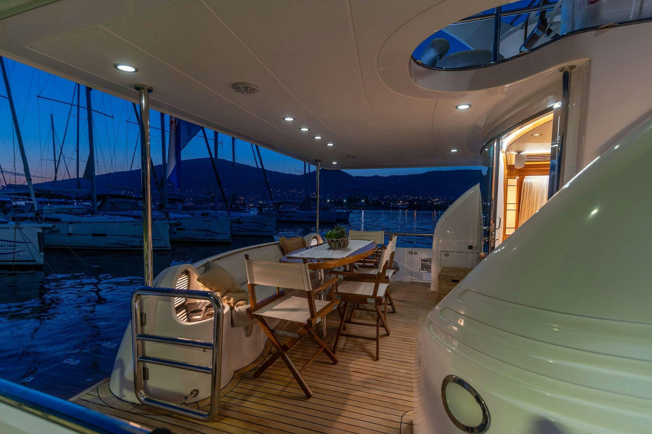 a boat with a table and chairs aboard HAPPY 3 Yacht for Charter