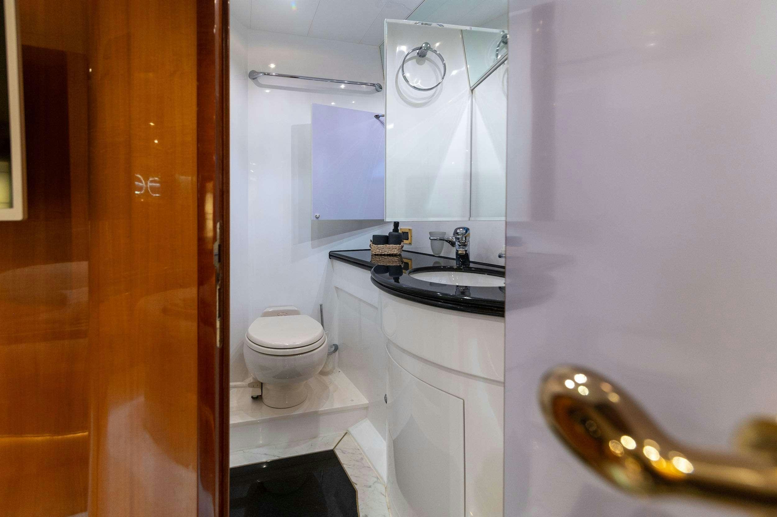 a bathroom with a sink toilet and a mirror aboard HAPPY 3 Yacht for Charter
