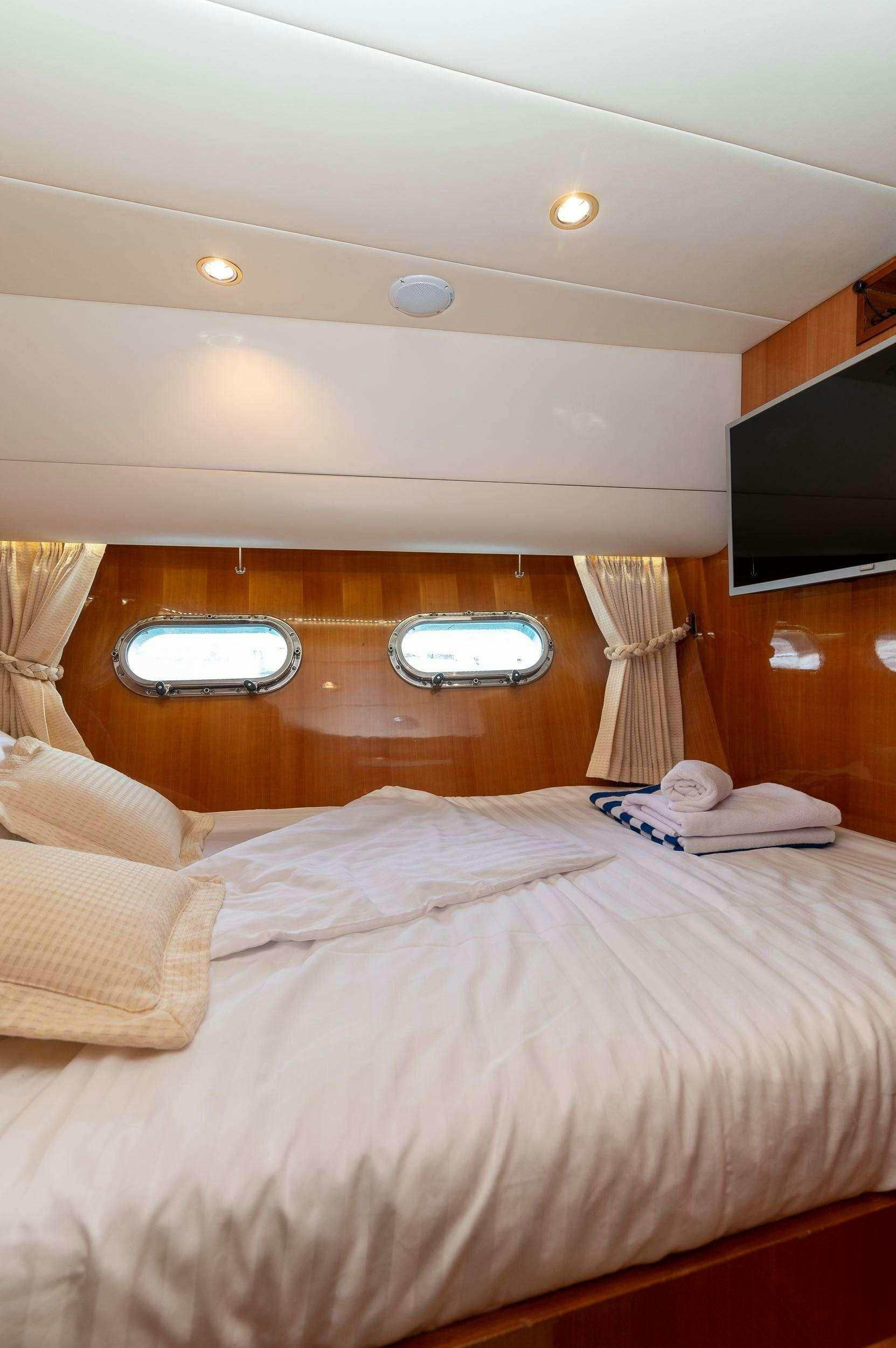 a bed with a wood headboard aboard HAPPY 3 Yacht for Charter