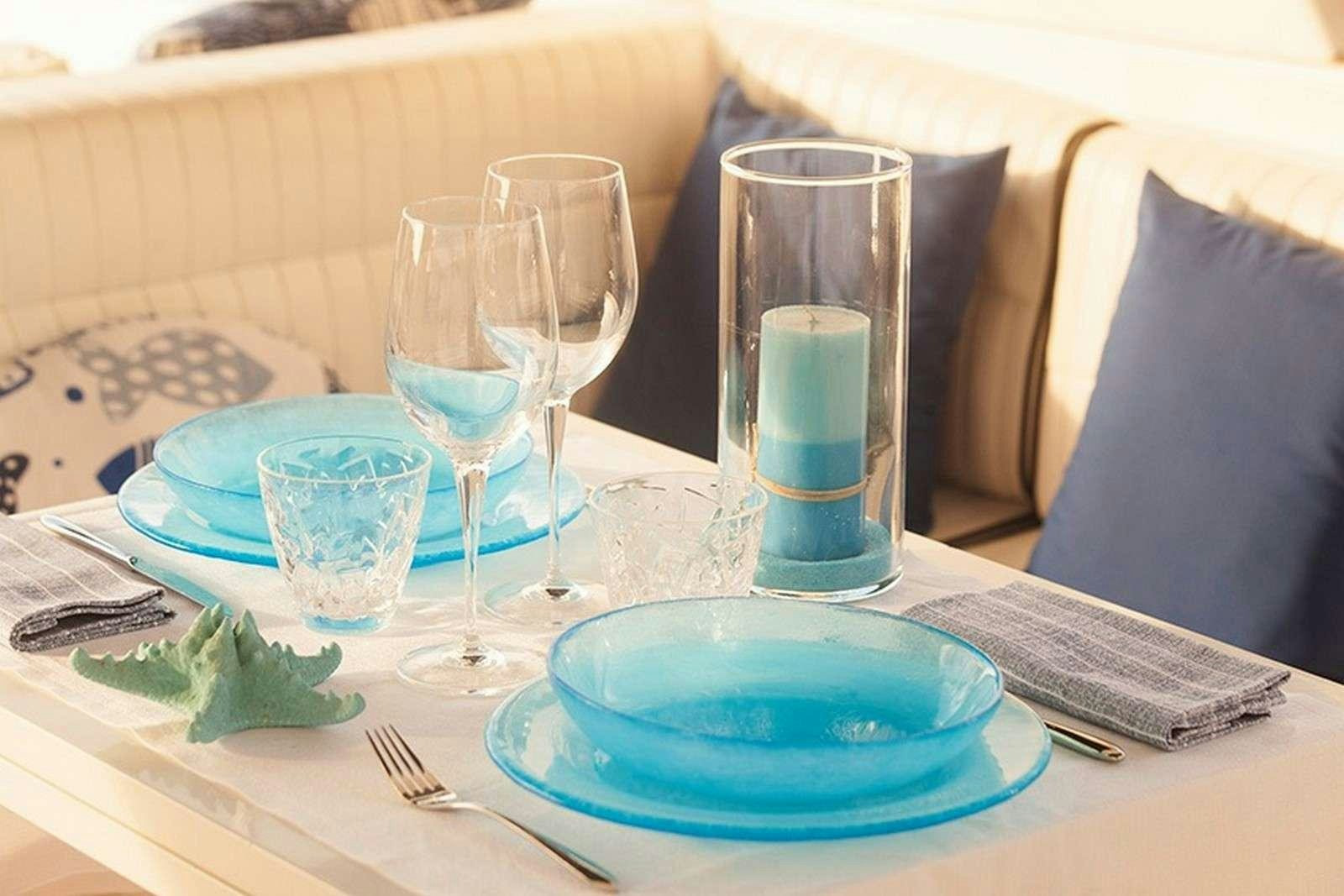 a table with empty glasses and plates aboard ARGENT'ARIA Yacht for Charter