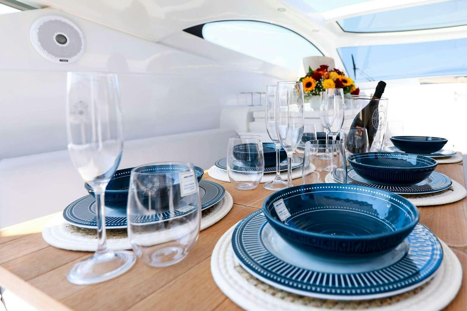 a table with plates and glasses aboard EVA II Yacht for Charter