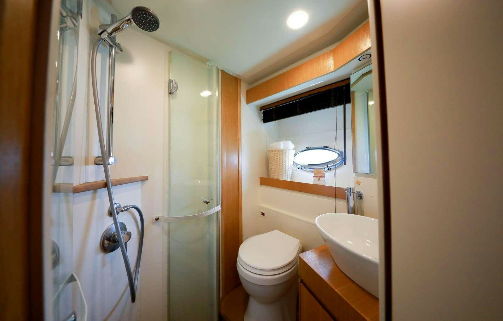 a bathroom with a glass shower door aboard EVA II Yacht for Charter