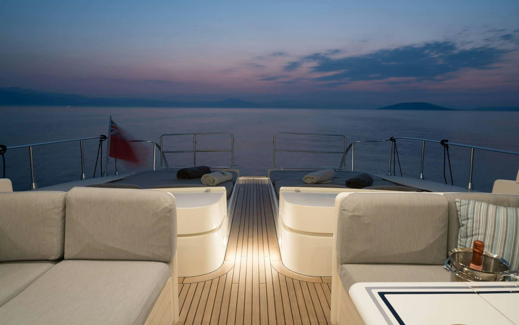 a deck with chairs and a body of water in the background aboard ROMACHRIS II Yacht for Charter