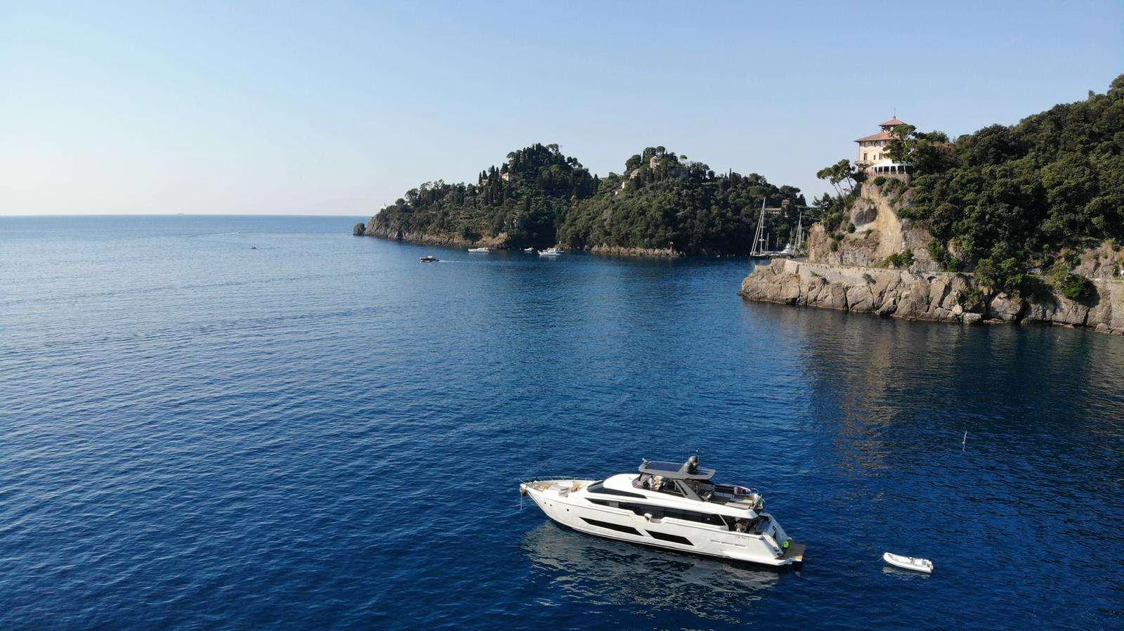 a boat in the water with Isola Bella in the background aboard E3 Yacht for Charter