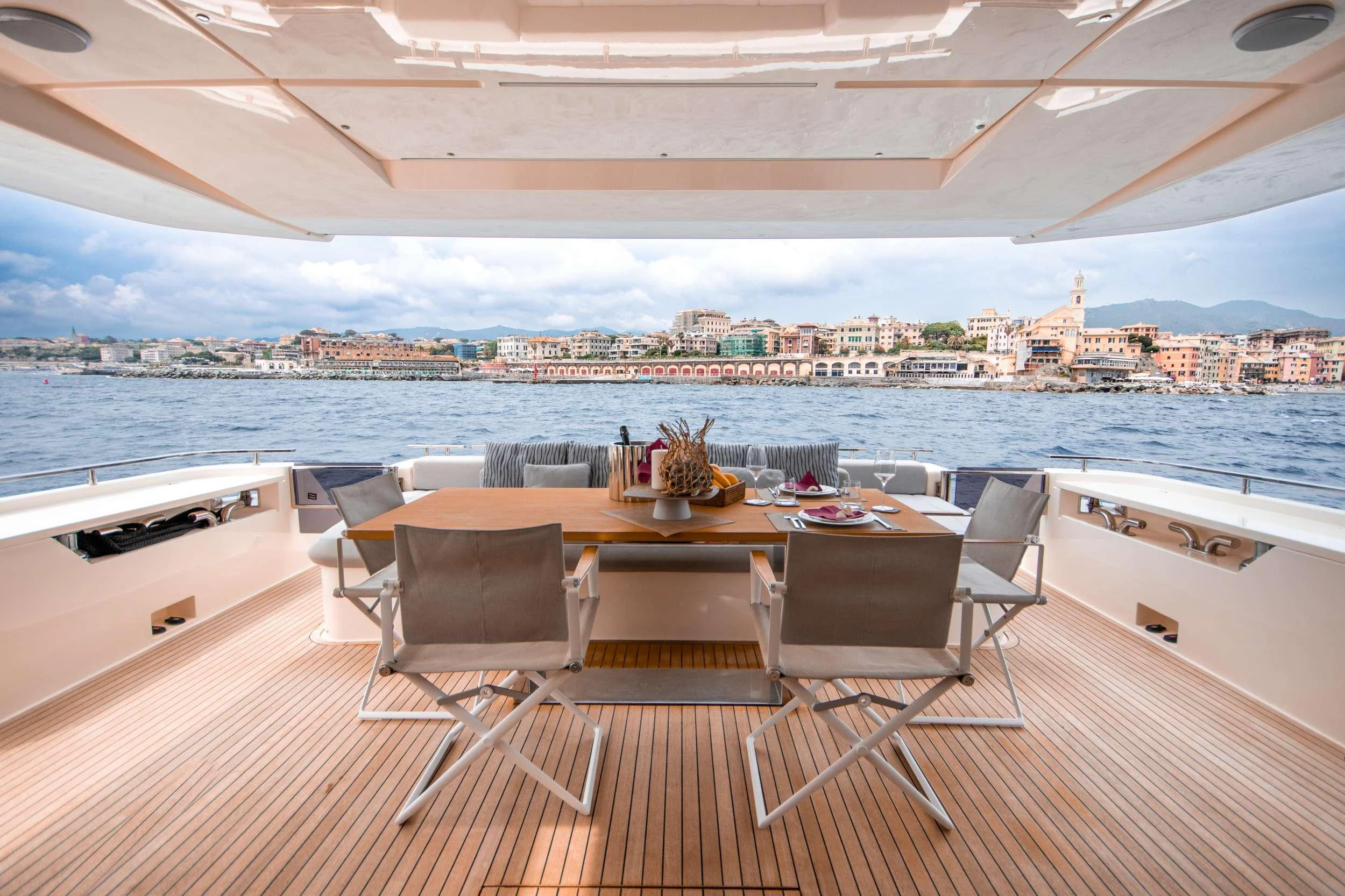 a table and chairs on a deck overlooking a city aboard E3 Yacht for Charter