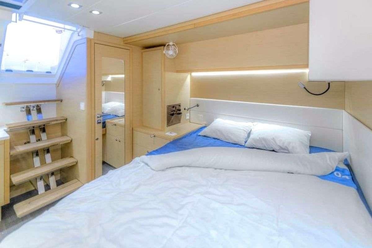 a bed with white sheets aboard GEMMA Yacht for Charter
