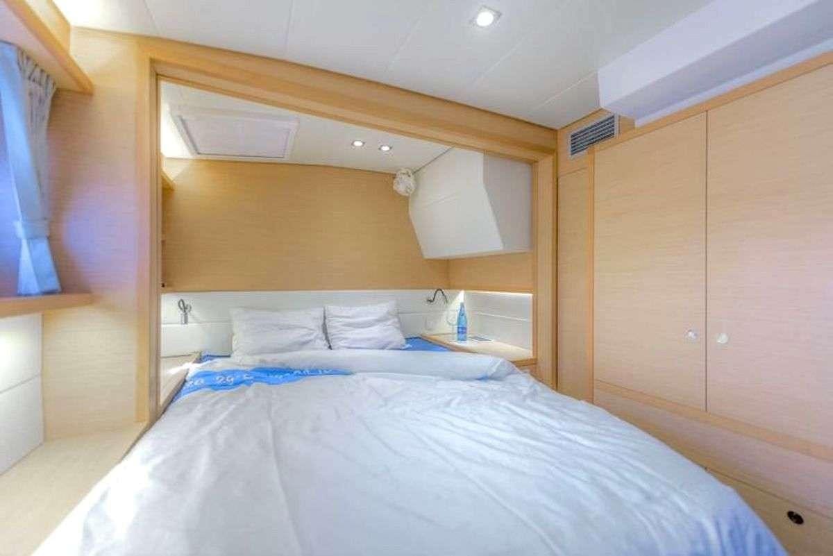 a room with a bed and a wood cabinet aboard GEMMA Yacht for Charter