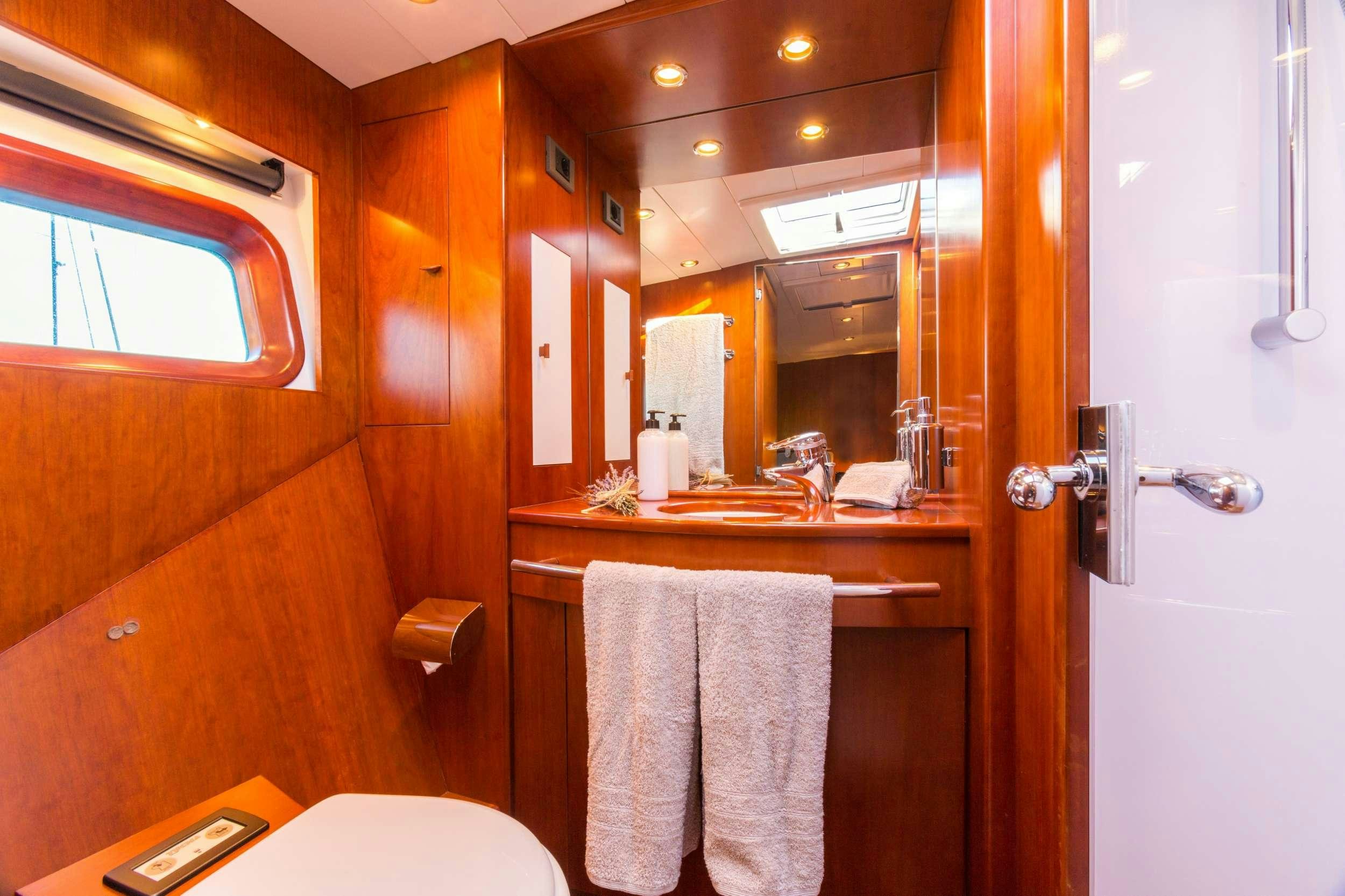 a bathroom with a mirror and towels aboard Free at Last Yacht for Charter