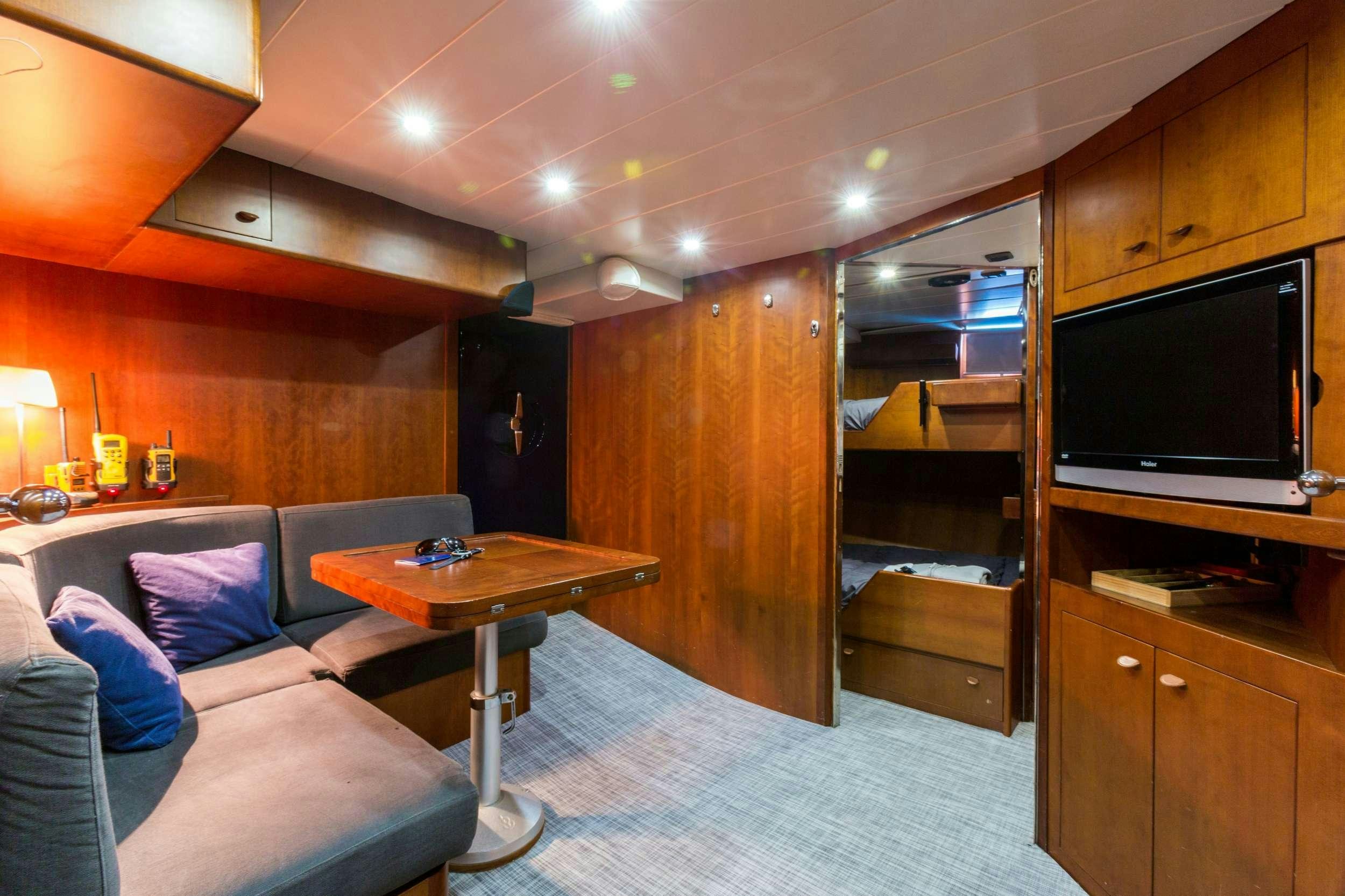 a living room with a couch and a television aboard Free at Last Yacht for Charter