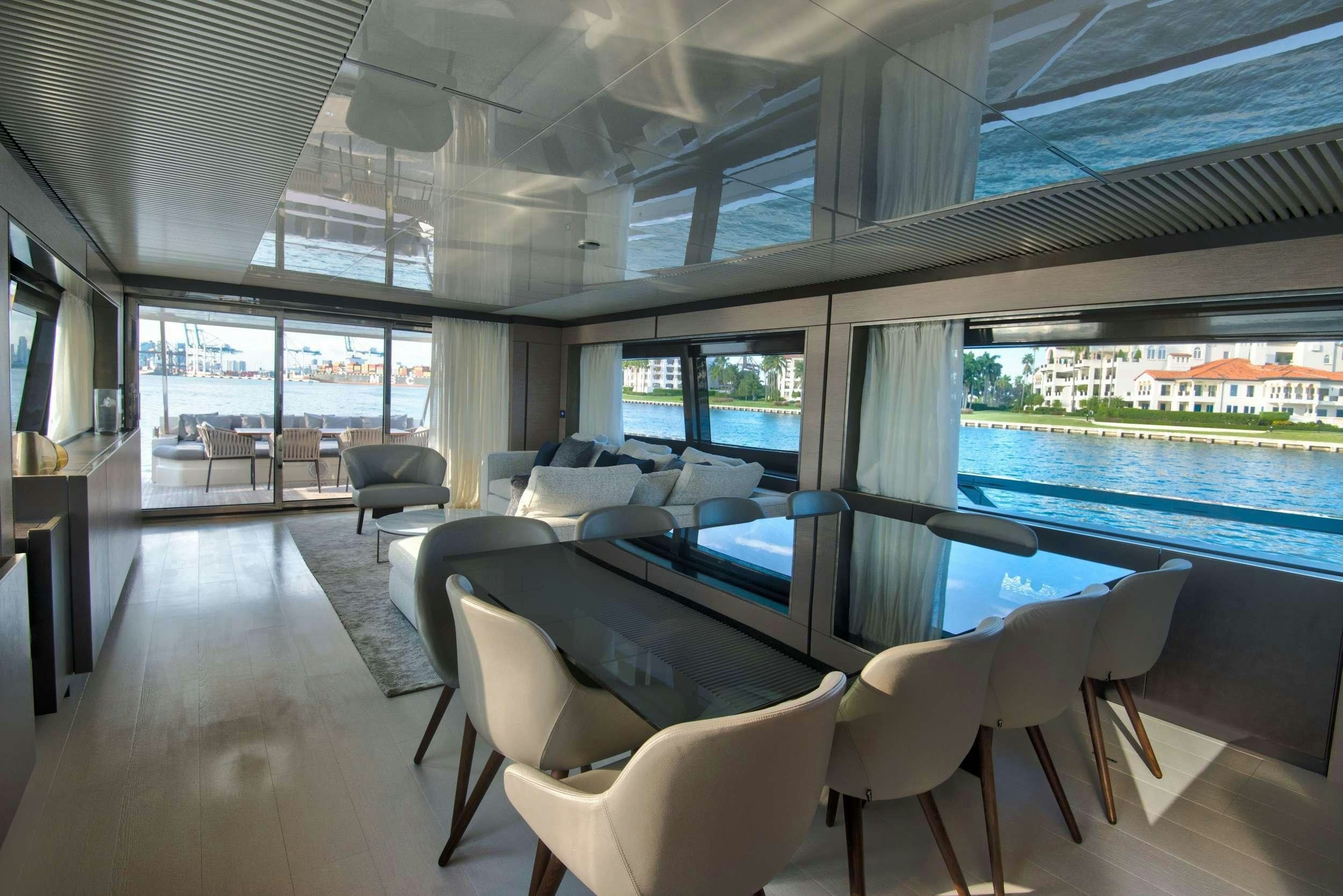 inside of a building with a large window and a large table with chairs and a large window with aboard 92' FERRETTI Yacht for Charter