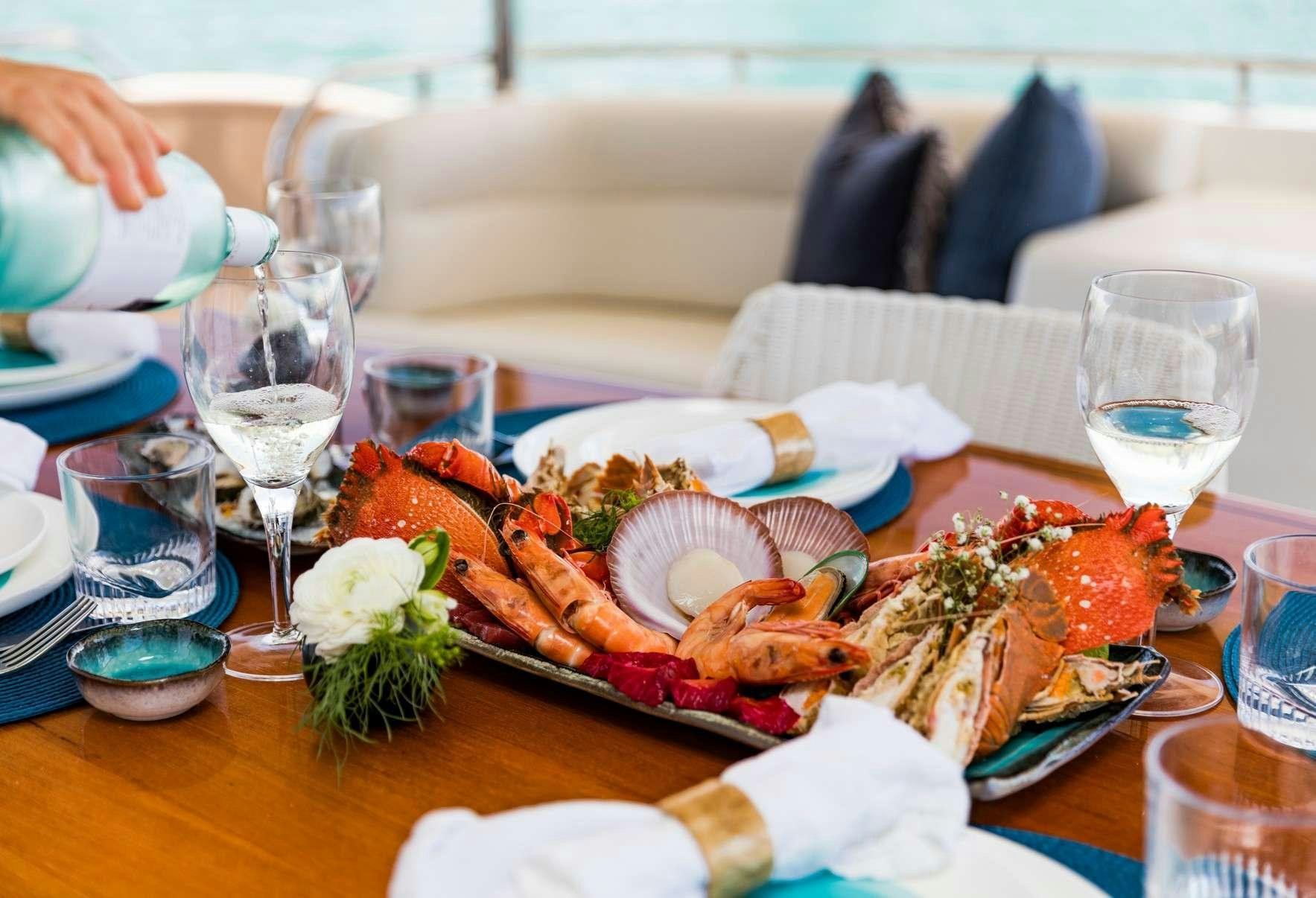 a table with food and glasses on it aboard TEXAS T Yacht for Charter
