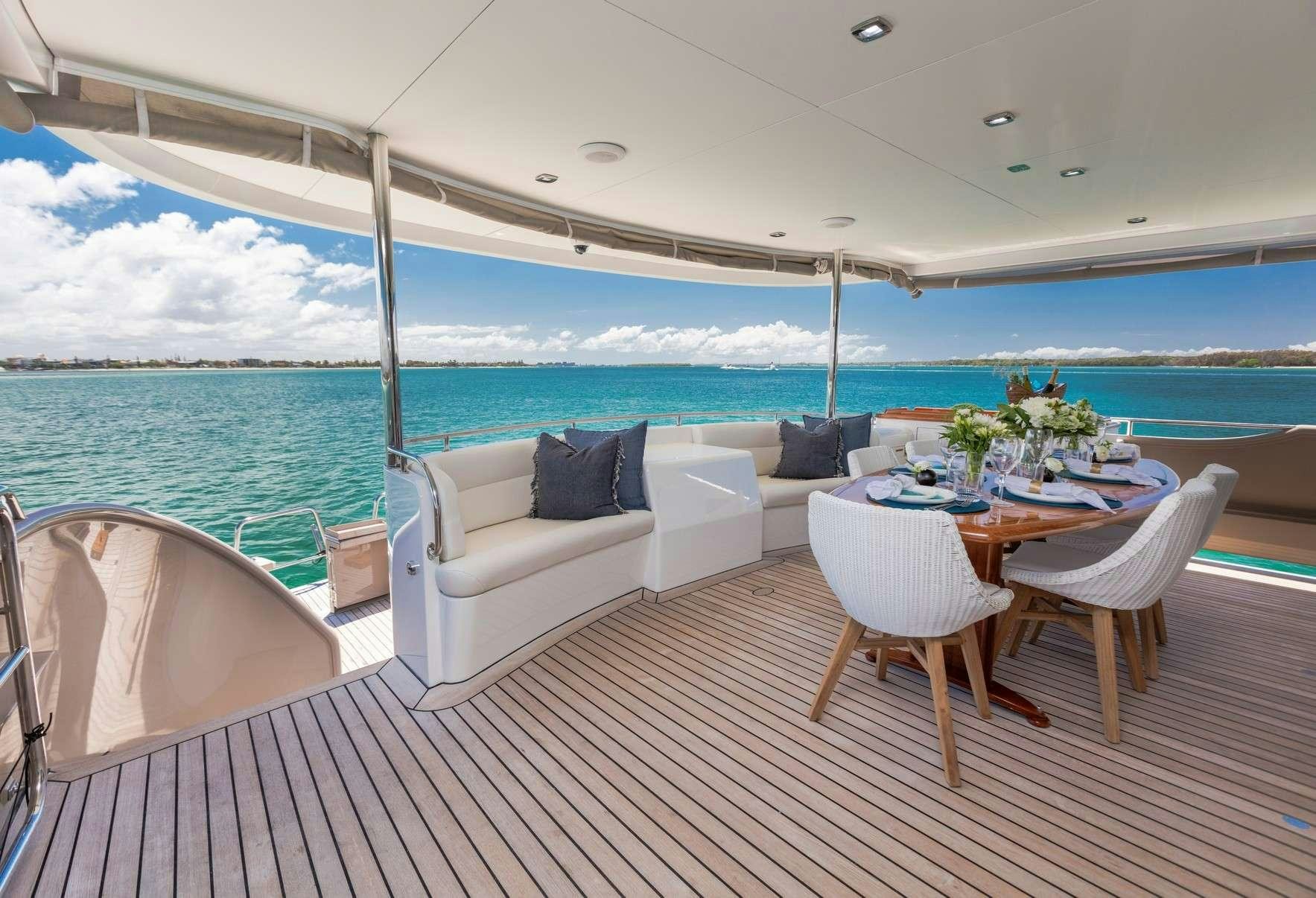a large white lounge chair on a deck overlooking a large body of water aboard TEXAS T Yacht for Charter