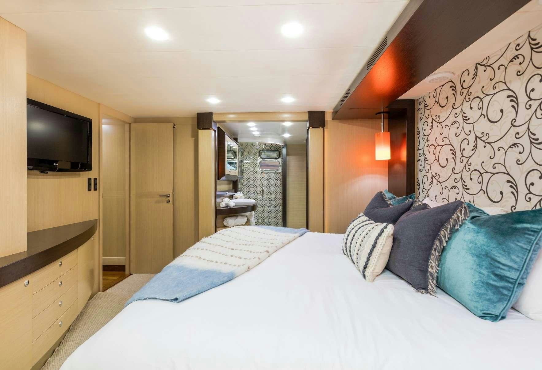 a bedroom with a bed and a television aboard TEXAS T Yacht for Charter