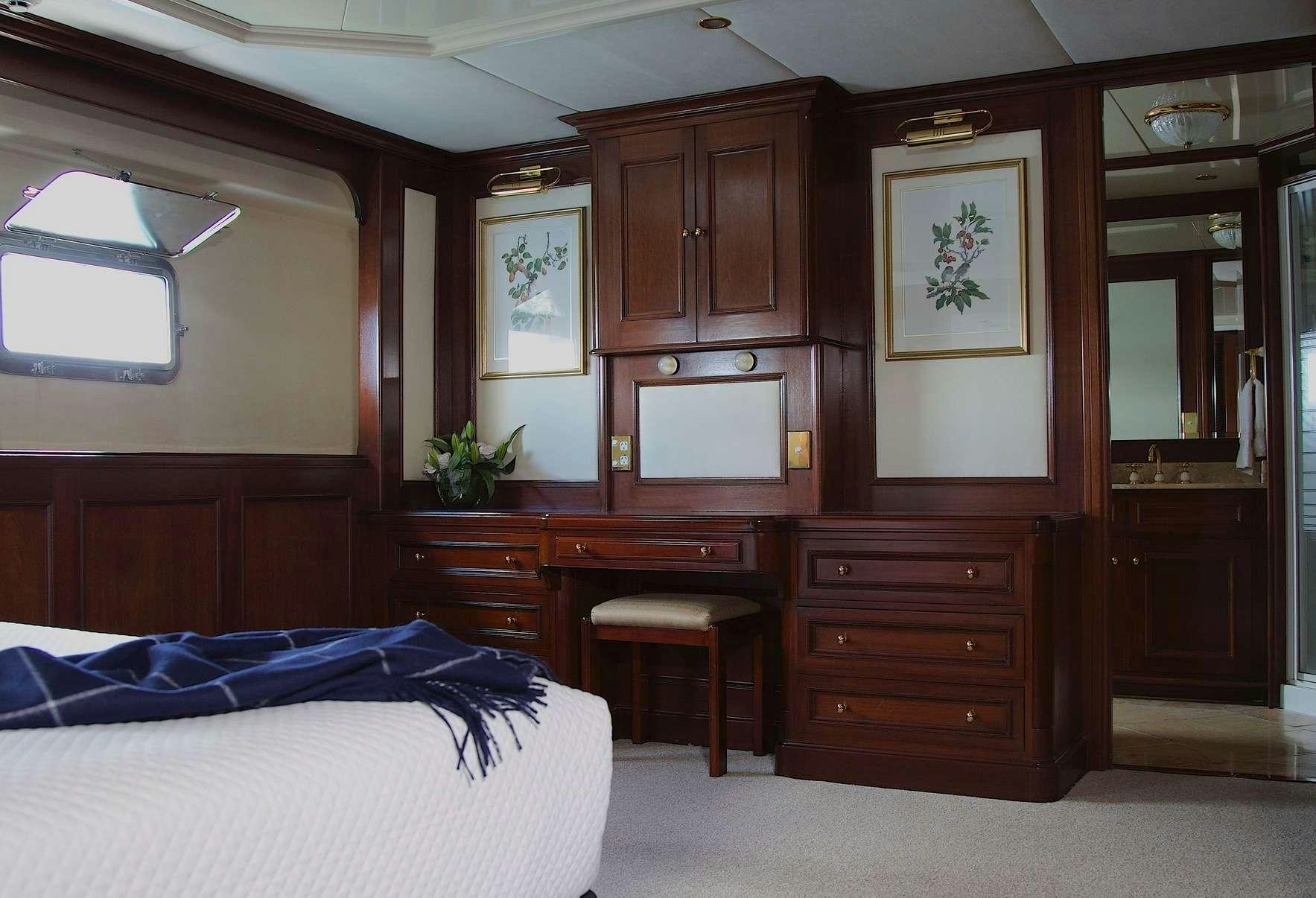 a bedroom with a desk and a bed aboard PACIFIC MERMAID Yacht for Charter